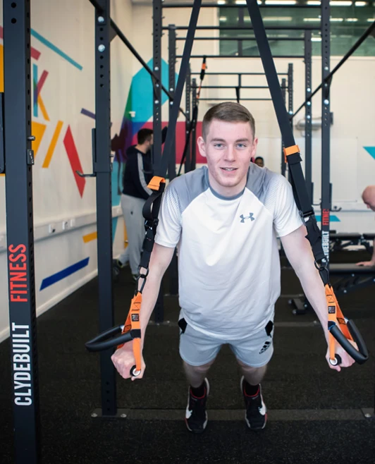Man doing TRX suspension training at Glasgow Kelvin College gym. Man doing TRX suspension training at Glasgow Kelvin College gym.